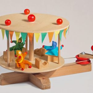 Mit seinen drei Mitfahrpüppchen unter dem Karusselldach ist das Karussell abfahrbereit.