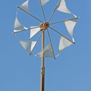 Das große Windrad Wirbeilwind mit den weißen Segeln dreht sich vor blauem Himmel