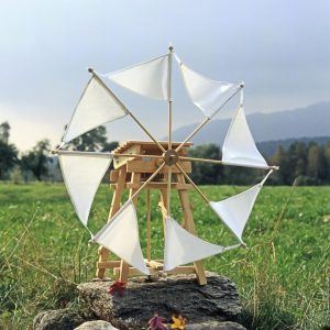 Die Segelwindmühle steht auf einem großen Stein im Wind