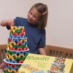 ein Mädchen baut den Turm des Bhaváti-Spiels