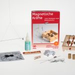 Die Teile des Experimentierkastens liegen um die Experimentierschachtel Magnetische Kräfte