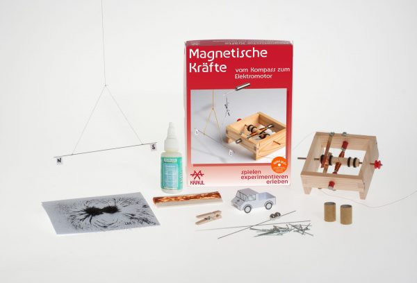 Die Teile des Experimentierkastens liegen um die Experimentierschachtel Magnetische Kräfte