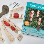 Die hölzernen Teile für den Bau eines Flaschenzugs liegen um die Experimentierschachtel Flaschenzüge