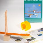 Eine Schrägseil-Brücke steht als Modell vor der Anleitung und der Schachtel Brückenbau