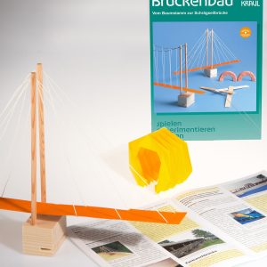 Eine Schrägseil-Brücke steht als Modell vor der Anleitung und der Schachtel Brückenbau