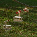 Die zwei Gondeln der Pendel-Seilbahn fahren im Garten am Seil auf und ab.