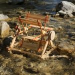 In einen kleinen Fluss gestellt dreht sich das Flussrad aus Holz.