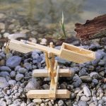 Wasser läuft in den Trog der Schnepfe, der gerade so voll ist, dass er sich nach vorne neigt und ausleert.