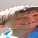 Ein verzerrter Jungenkopf im Fratzenspiegel