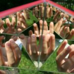 Viele Finger spiegeln sich im Kaleidoskop
