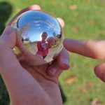 Ein Mädchen experimentiert mit den Spiegelkugel-Experimenten