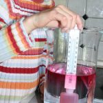 Ein Mädchen experimentiert mit dem Experimentierkasten Wind und Wetter