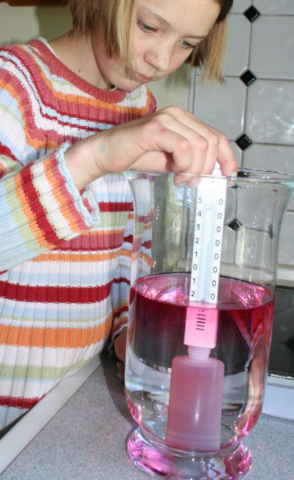 Ein Mädchen experimentiert mit dem Experimentierkasten Wind und Wetter
