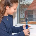 Das Wetterglas wird von einem Mädchen aufs Fensterbrett gestellt