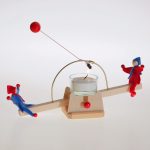 Ein rot-blaues Püppchen-Paar wippt auf der Lichtwippe